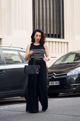 a lady in a striped tank top and a pair of black wide leg pants